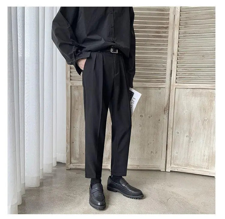 Black pleated men loose fit straight leg suit pants with a tailored fit and subtle texture.