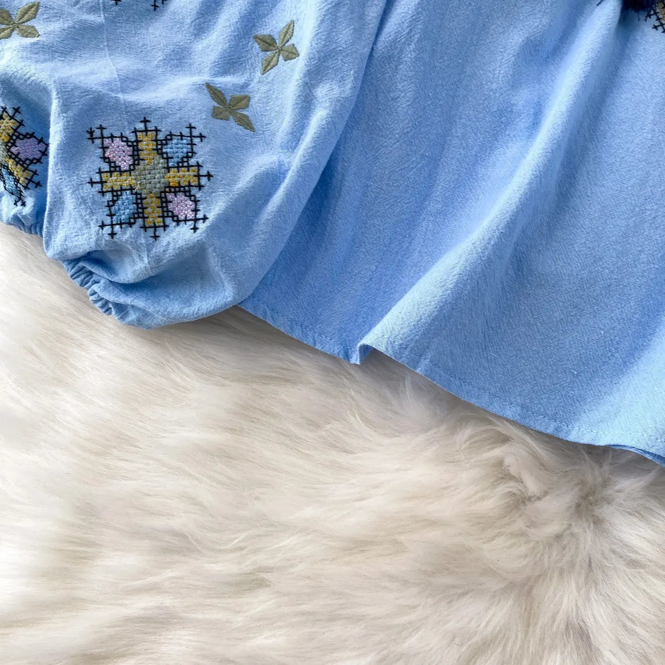 light blue cotton embroidered lantern sleeve tie neck blouse with intricate cross-stitch floral and geometric patterns