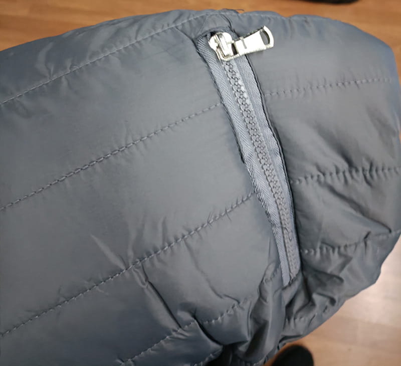 Doudoune matelassée grise pour homme avec col montant et fermeture à glissière argentée, conçue pour la chaleur et le style.