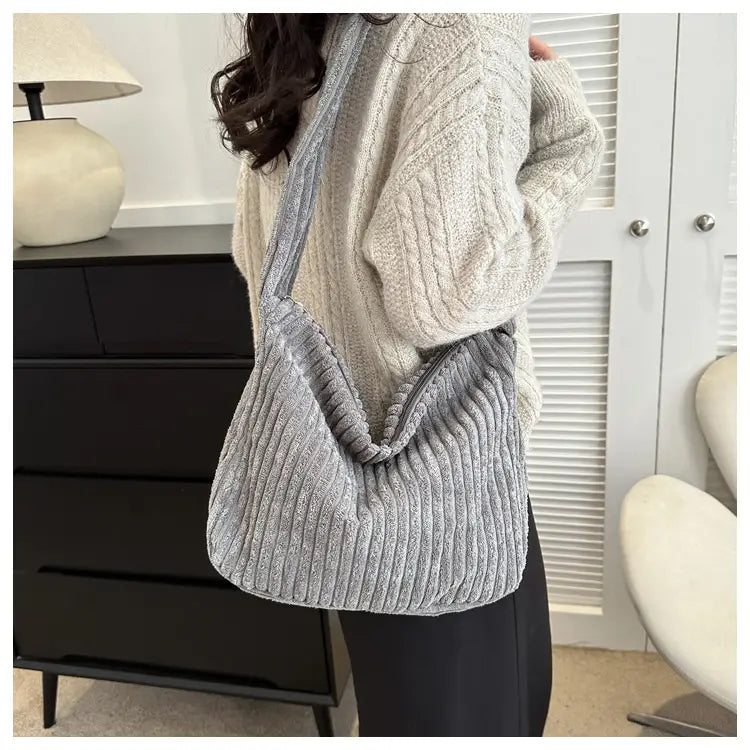 Grau-schattierter Corduroy-Schulterbeutel mit strukturiertem, geripptem Muster und weicher, nachgebender Silhouette, ausgelegt für minimalistisches Streetwear.