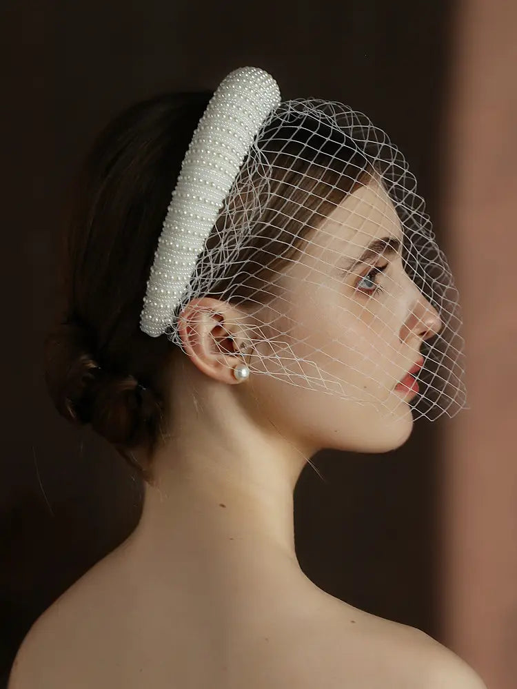 A delicate white beaded vintage French Hepburn bridal veil headband with a fine mesh veil designed for weddings.