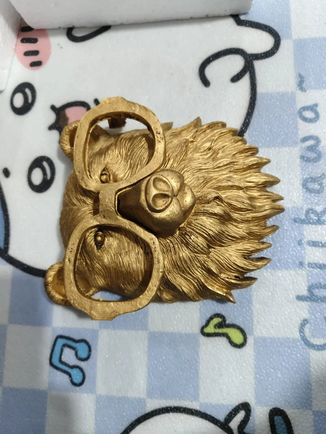 Golden lion head brooch in brass resin with detailed fur and round glasses featured as part of animal head wall decor figurines.