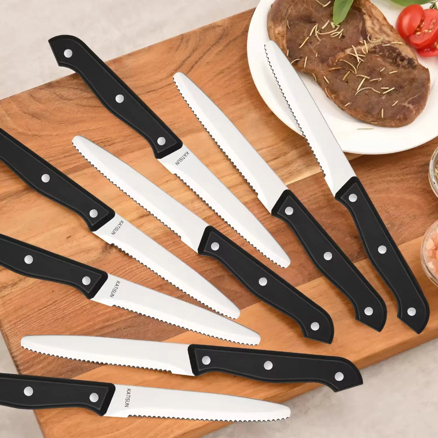 Juego de ocho cuchillos para carne de acero inoxidable con mango negro, con bordes dentados y marca Katsu, de un set de 12 piezas de cuchillos de cocina de acero al carbono con mangos de ABS.