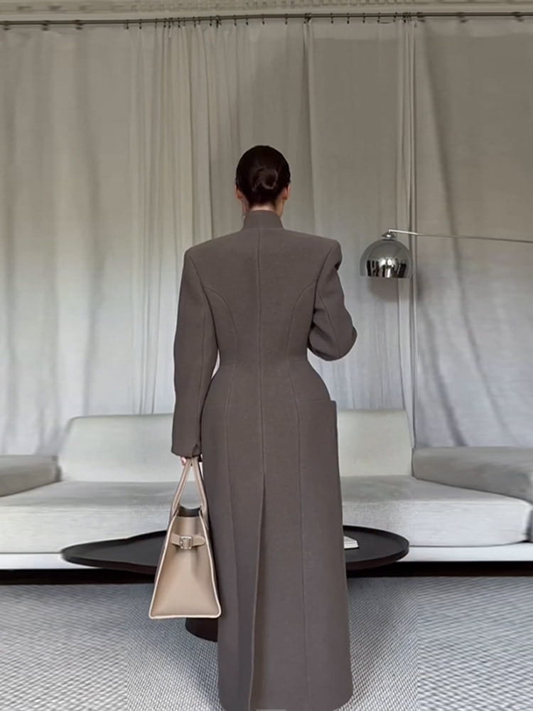 beige structured handbag with minimalist design and metallic clasp paired with charcoal gray wool coat for women waisted long outerwear