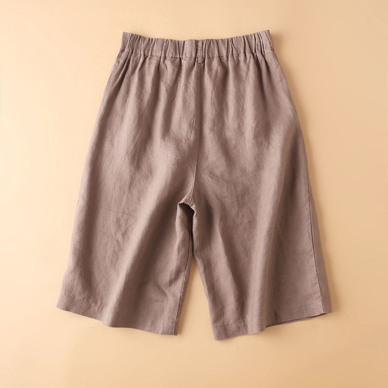 ベージュのコットンリネン素材クロップドパンツ（3/4丈）。ハイウエストの伸縮性ウエストバンドと、リラックスしたストレートレッグのカットを備え、カジュアル用途に適する。