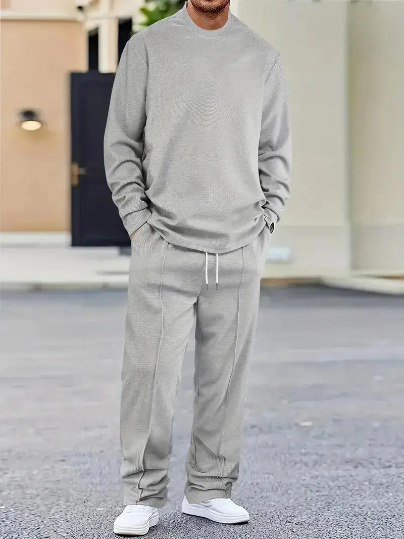 Mens minimalist solid color sweatshirt jogger set featuring a gray ribbed knit sweatshirt with matching joggers and white sneakers.