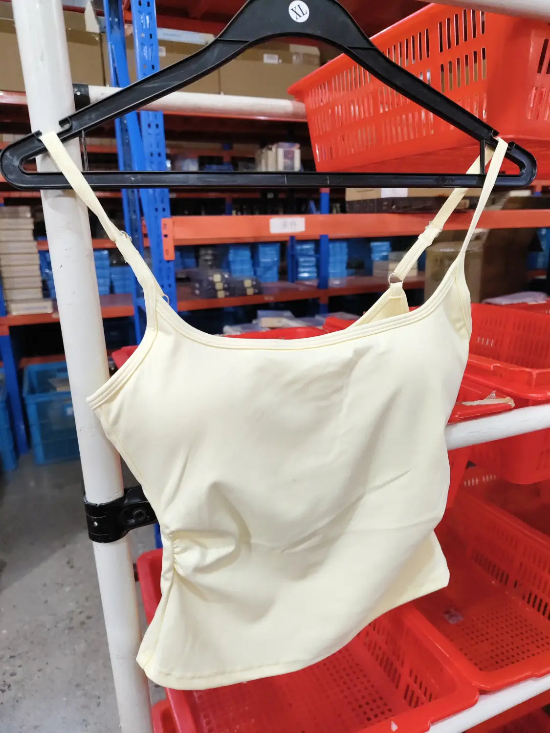 Camiseta sin mangas acolchada color crema con tirantes finos y escote ligeramente fruncido, confeccionada con material de secado rápido, para uso en entrenamientos de ropa deportiva y entrenamiento activo.