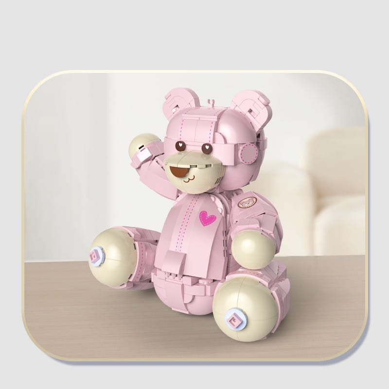Rosa roboterartiges Teddybär-Bausteinspielzeug mit beigen kugelförmigen Gelenken und einem kleinen pinken Herz-Emblem auf seiner Brust