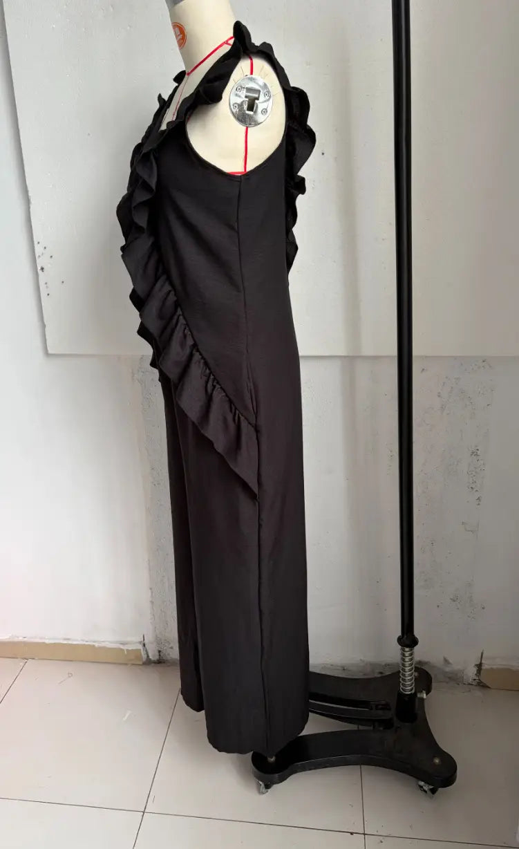 black ruffled sleeveless dress with a v-neck displayed on a mannequin, suitable for resort wear.