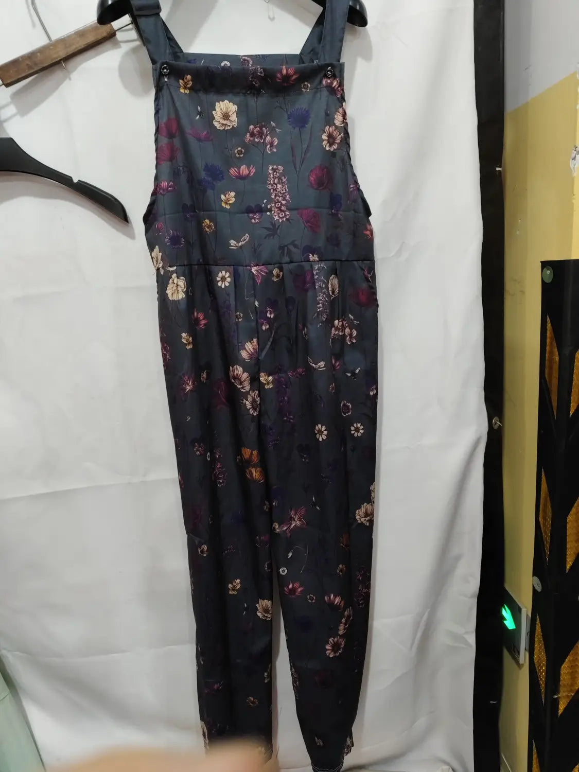 Dark blue floral-patterned denim printed suspender overalls with a fitted waist and adjustable shoulder straps for casual wear.
