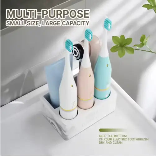 A sleek marble-patterned ceramic toothpaste holder cradling three colorful electric toothbrushes with pastel handles and turquoise bristles for bathroom organization.