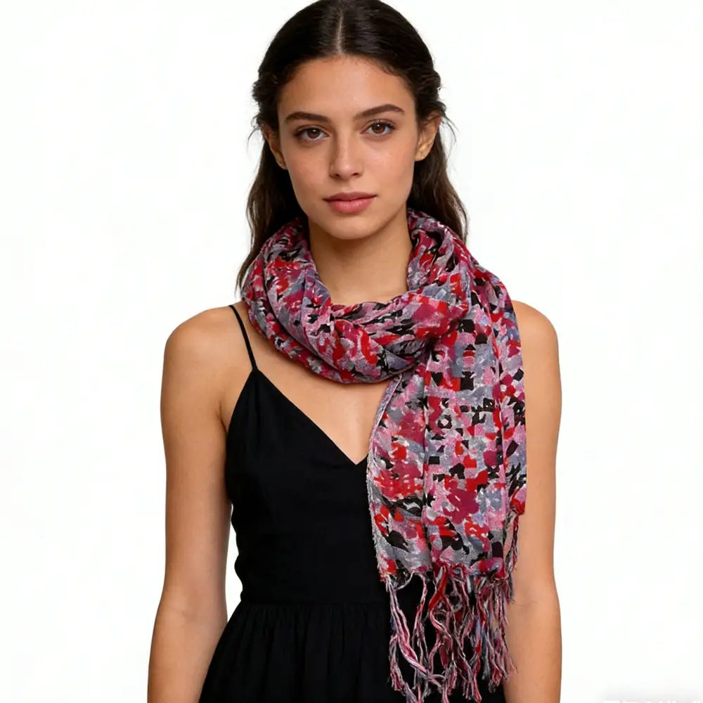 Una bufanda larga de viscosa fluida roja, suave y ligera, con un vibrante patrón floral rosa, rojo y gris, y bordes delicadamente con flecos para vestidos.