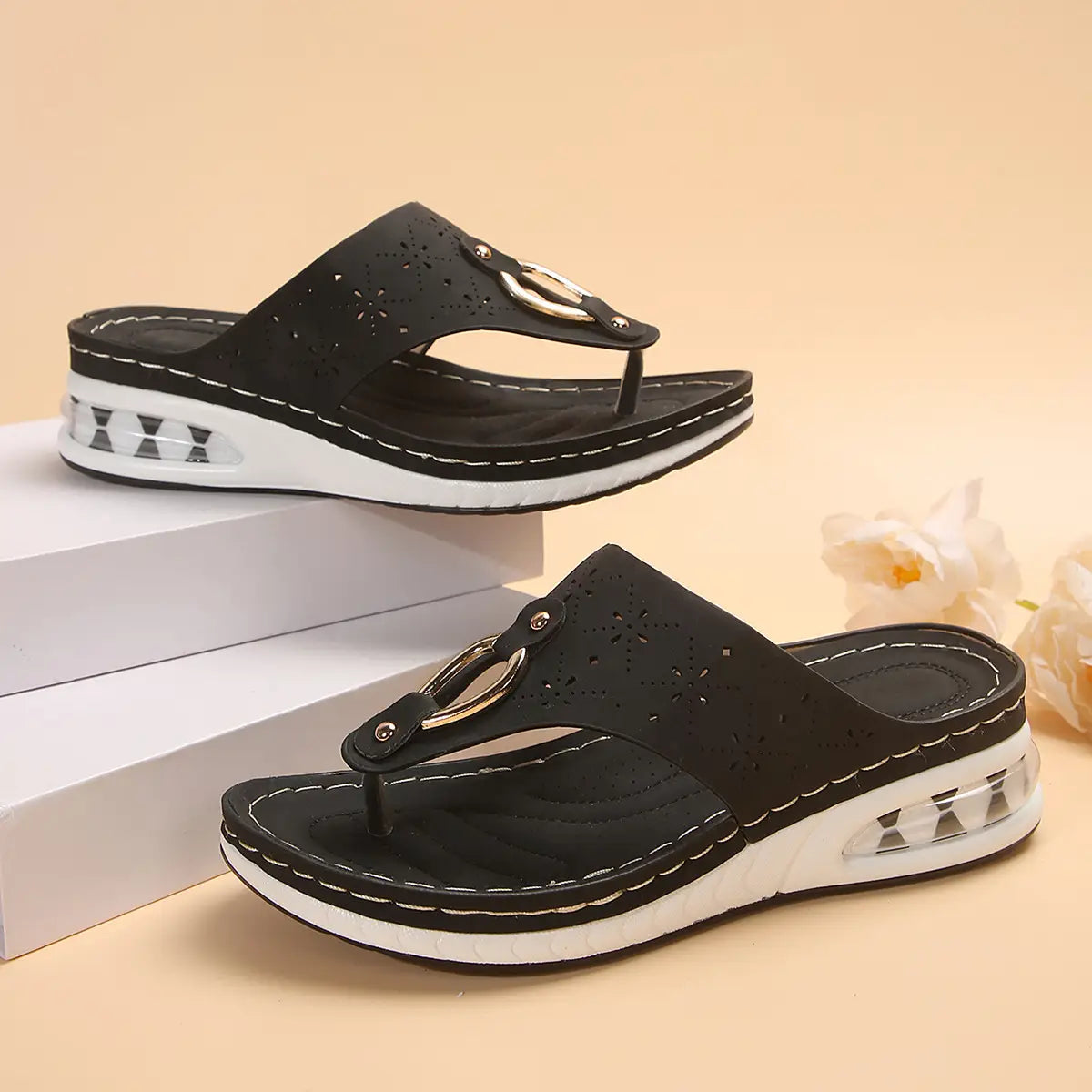 black perforated leather air cushion thong sandals with white cushioned wedge sole and silver toned metal buckle