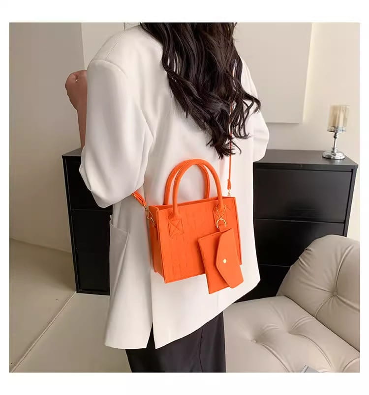 Leuchtend orangefarbenes Filzhandtaschen-Set mit oberen Henkeln, abnehmbarem Umhängegurt und passender Geldbörse.
