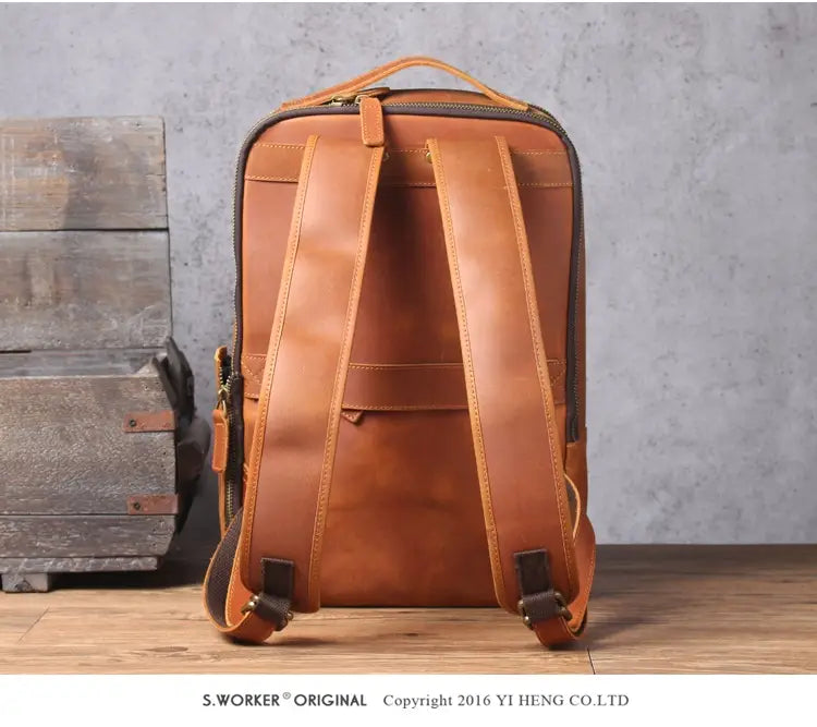 Men’s vintage leather backpack in dark brown cowhide featuring a tan leather exterior with sturdy straps and a classic minimalist design.