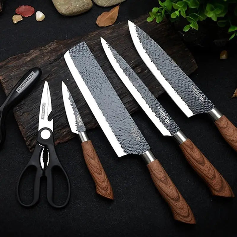 Set of four kitchen knives with hammered steel blades and wooden handles accompanied by black plastic kitchen shears in a 6 piece hammered steel kitchen knife set with case.
