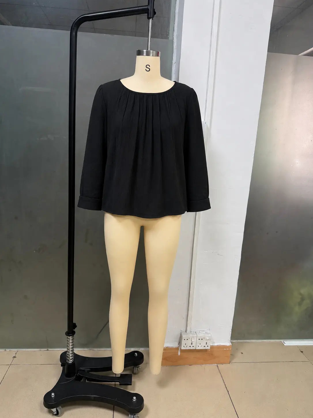 Une blouse ample en lin et coton pour femmes, noire, avec manches longues, encolure froncée et tissu doux.