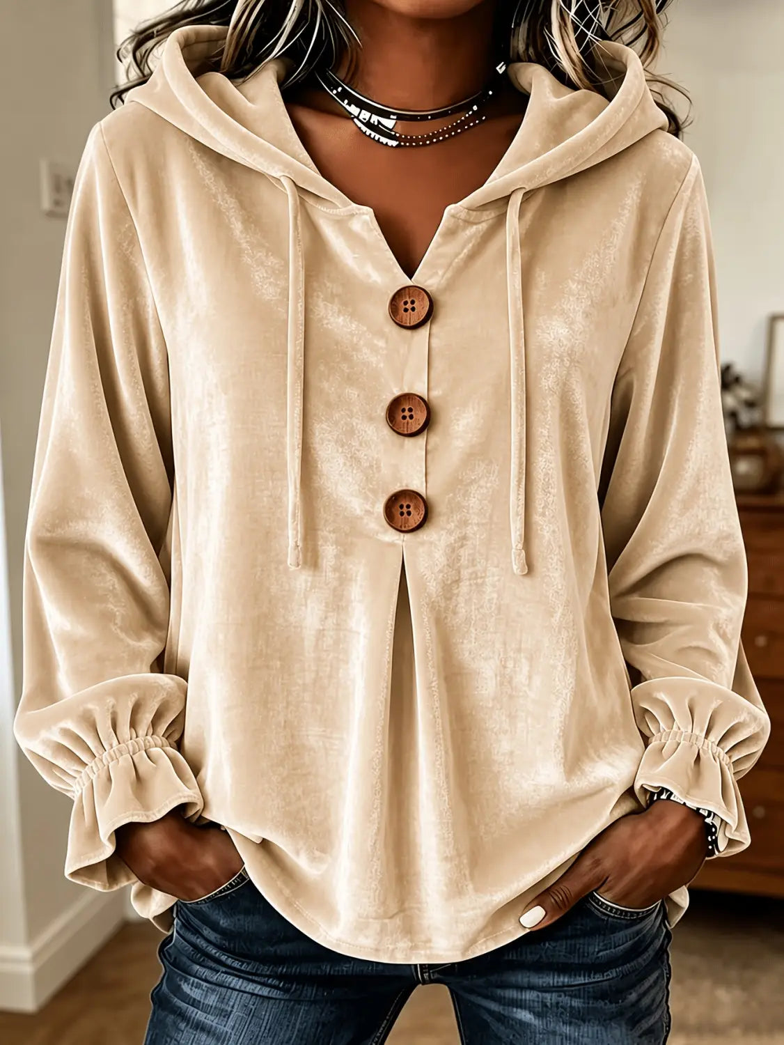Sudadera de terciopelo color beige con botones de madera y puños fruncidos, exhibida de frente.