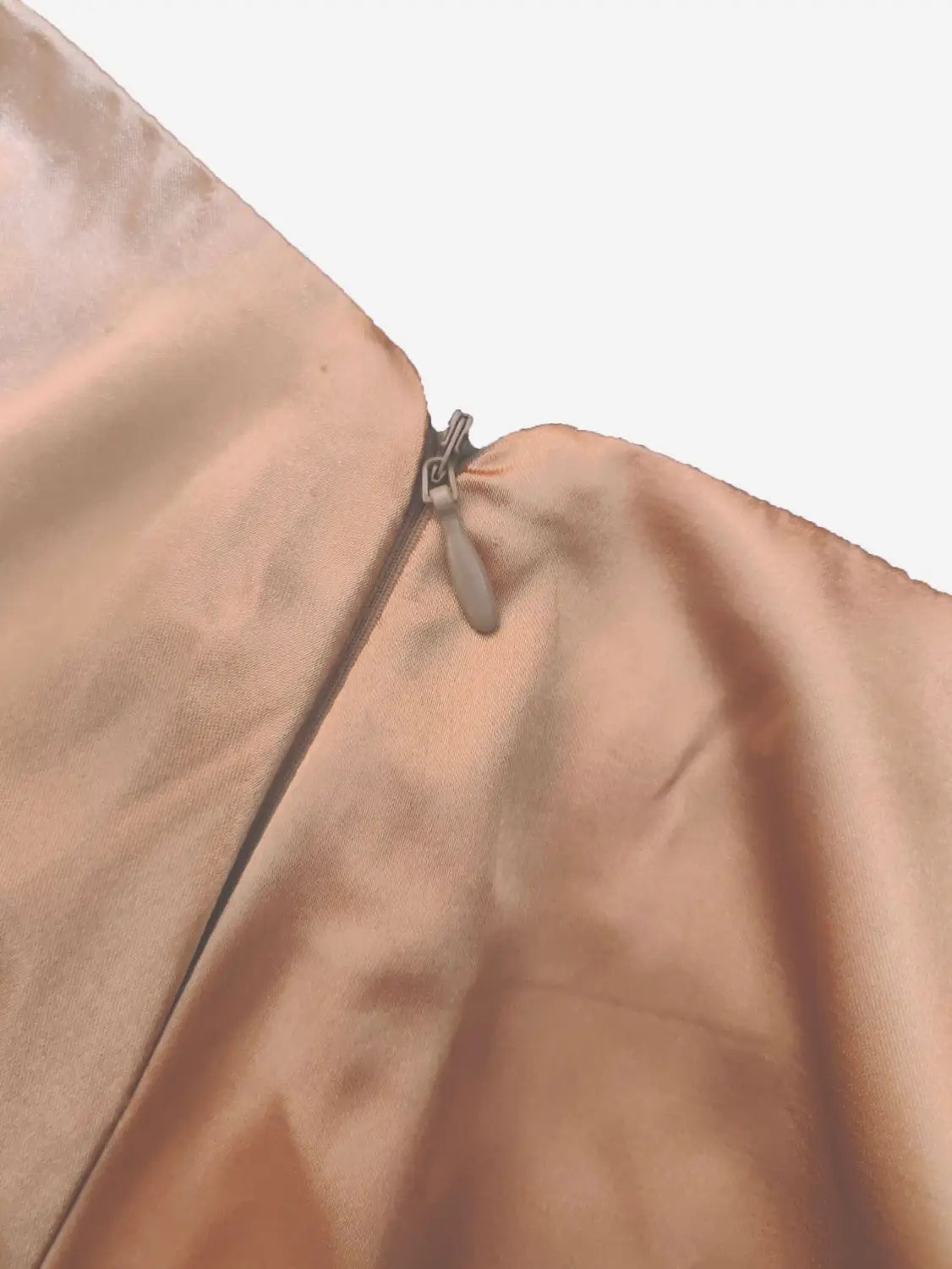 Ein zarter, pfirsichfarbener Satinkleidrock (Midi) mit einem hoch sitzenden, fließenden Design und einem metallischen Zipper-Anhänger in Roségold aus Seide.