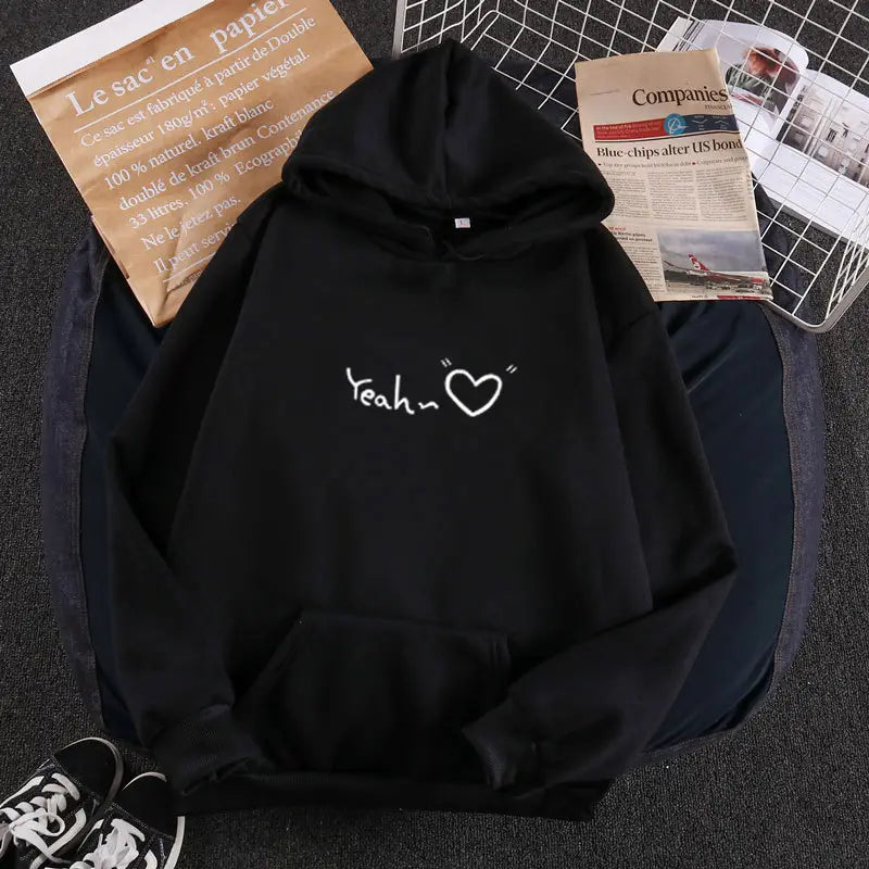 Sudadera con capucha aislada y forro polar negra con texto 'yeah' blanco y diseño de corazón en la parte posterior.