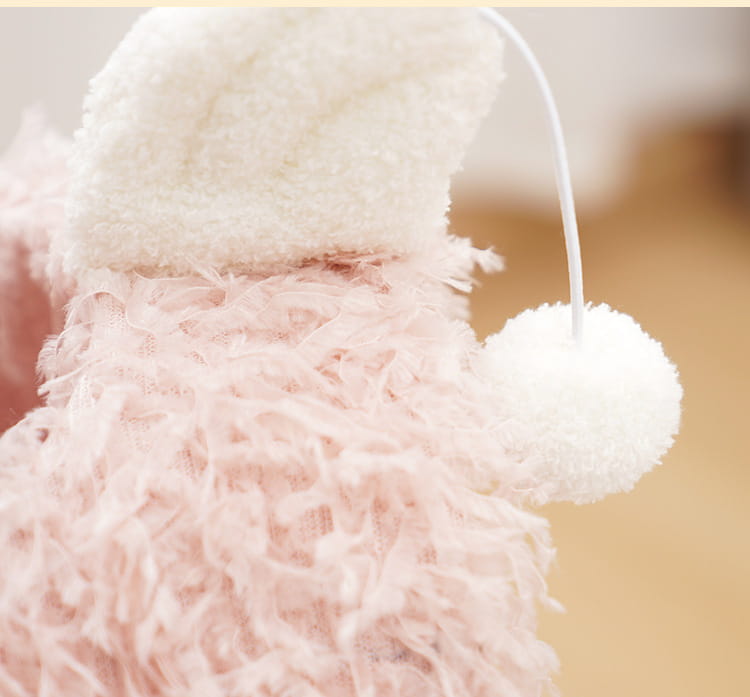 juguete de peluche esponjoso de color rosa con forma de animal, que lleva un gorro blanco esponjoso con un pompón a juego en la oreja, junto a un poste rascador de sisal con nido en forma de flamenco rosa para gatos