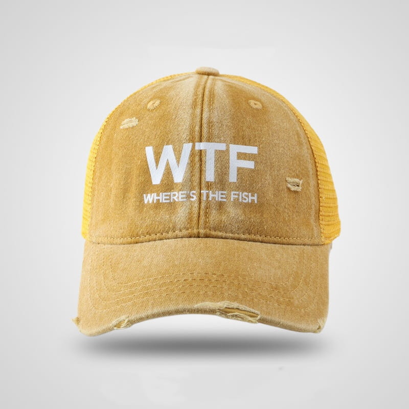 A distressed mustard-yellow fishing trucker hat with white embroidered text reading wtf where’s the fish and mesh side panels.