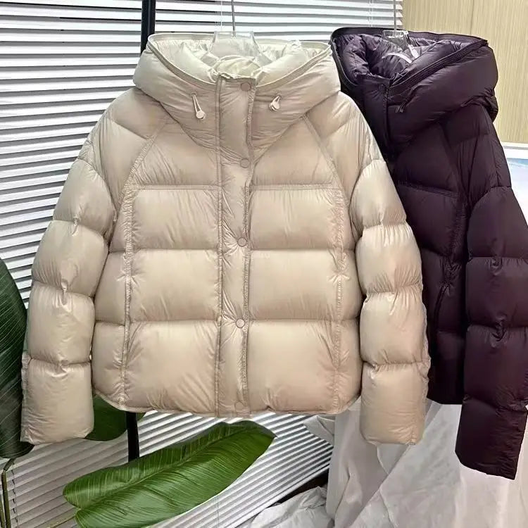 Beige puffer jacket loose hooded winter coat with a hood and quilted design featuring a shiny nylon exterior.