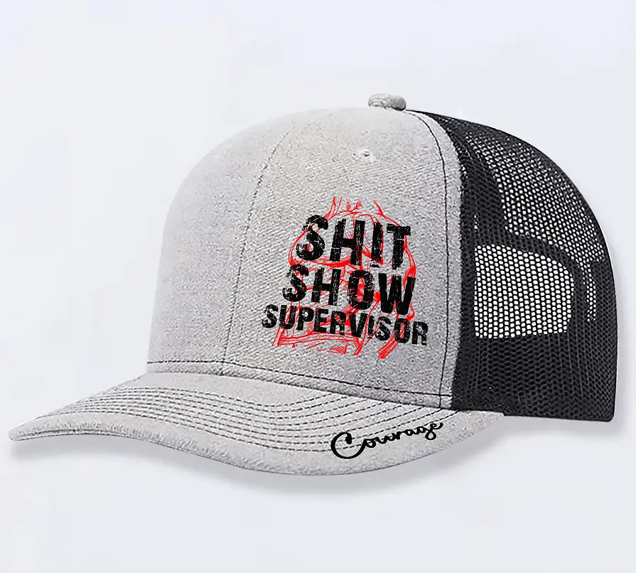 Gray and black trucker hat with shit show supervisor printed in bold black letters over a red flame design and courage scripted on the brim for men.