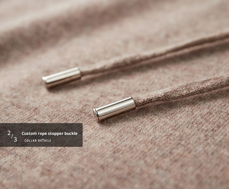 Silberne zylindrische Seilstopper-Verschlüsse an beigen, strukturierten Kordelzügen für einen Herren-Strickpullover mit Kapuze, locker geschnitten