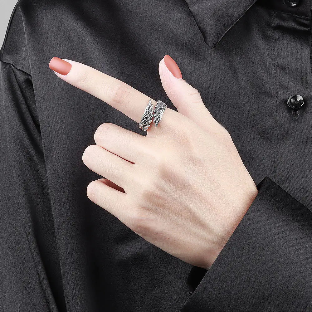silver twisted wire ring made of 925 sterling silver detailed as an angel wing worn on a finger