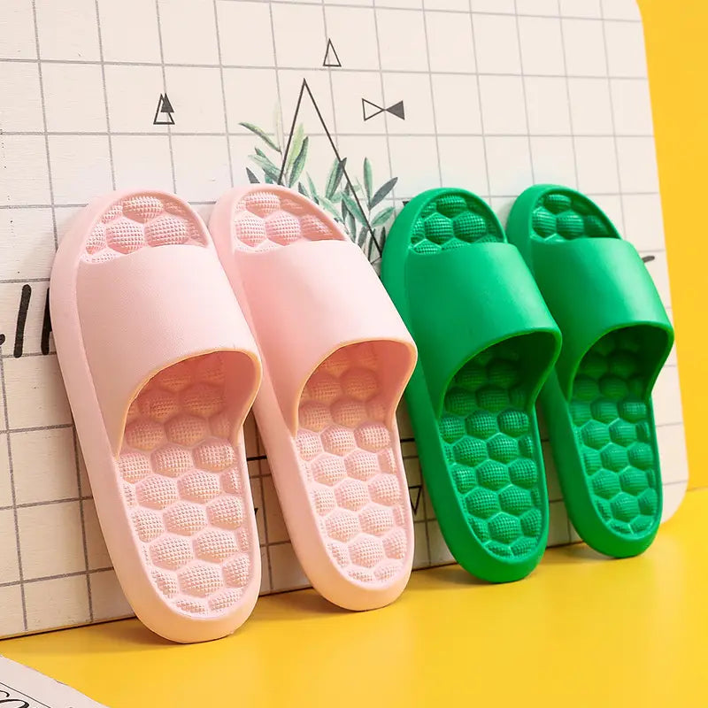 pink and green plastic massage slippers with honeycomb textured rubber slide soles