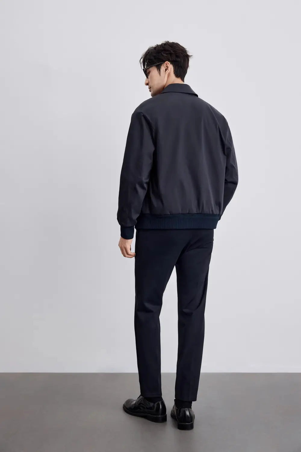 Herren-Jacke mit gestepptem Revers, für die Geschäftsführung, in Schwarz, mit gerippten Bündchen und Saum, von der Rückseite abgebildet