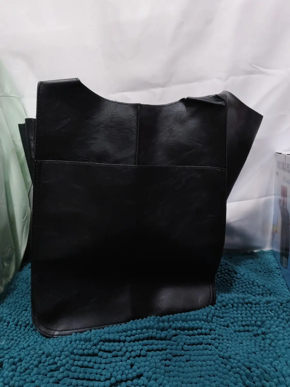Black leather tote bag with large capacity, soft slouchy shoulder design, structured minimalist shape, and slightly worn texture.
