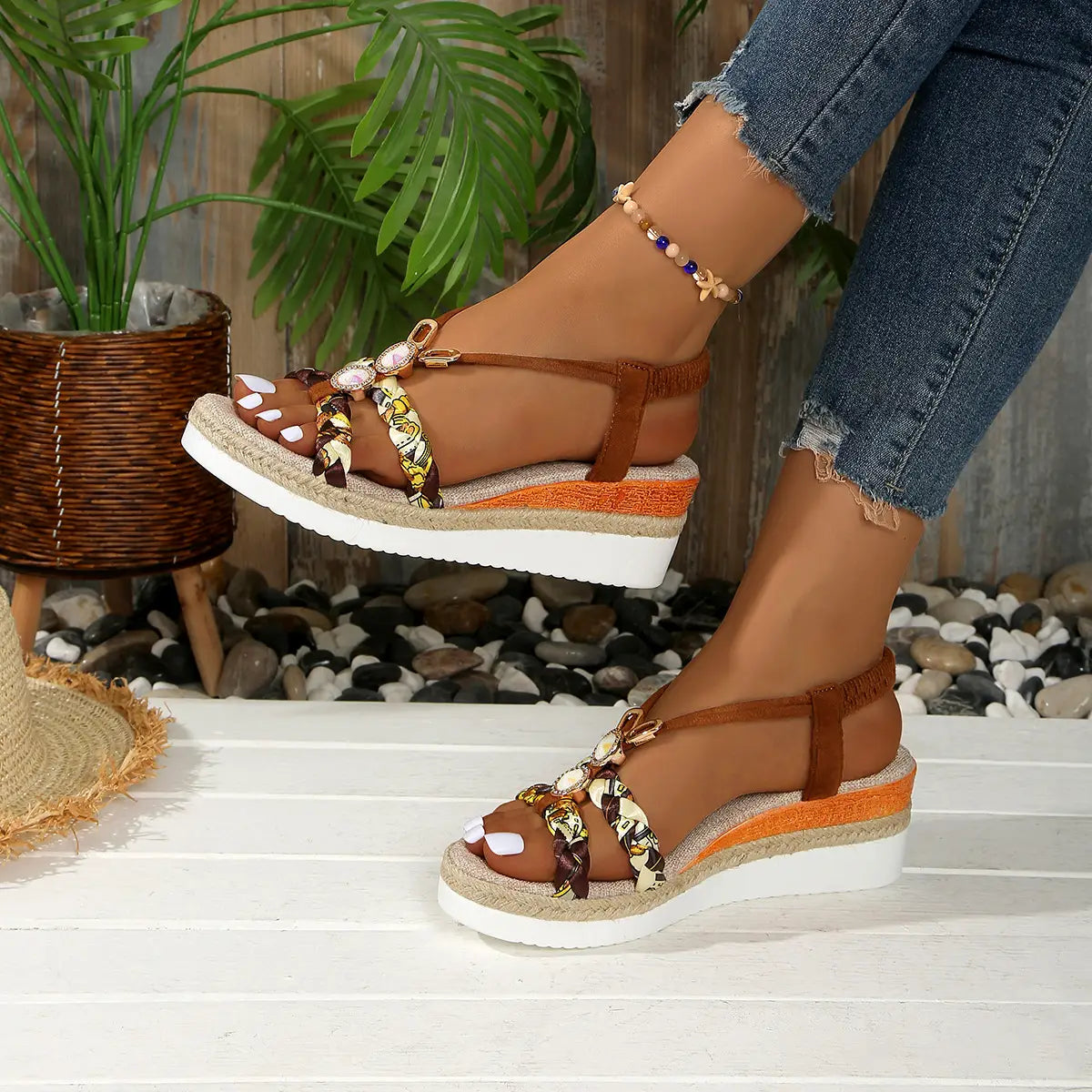 Sandalias tipo cuña marrones para mujer con suelas de espadrille tejidas y correas trenzadas decorativas, con tela con patrón y adornos tipo concha.
