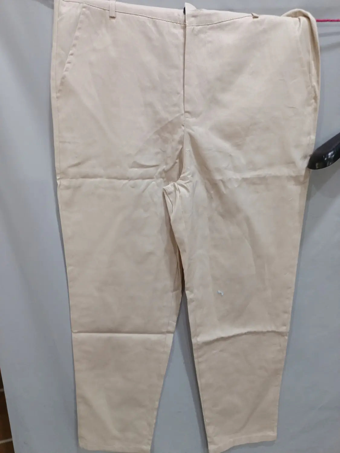 Beige cotton men’s casual slim fit chinos featuring a classic straight-leg cut and visible front pockets.