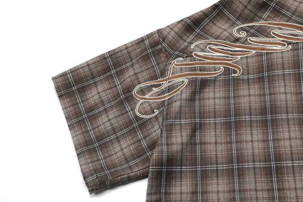 Brown and white plaid short sleeve shirt with intricate cursive embroidery along the shoulder designed for casual wear.