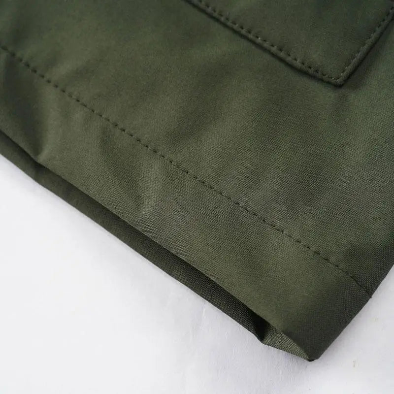 olive green mens outdoor fleece hooded jacket casual shell coat fabric showing neat stitching along the hem and pocket edge