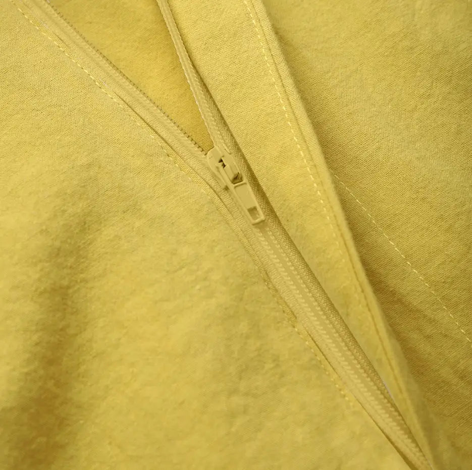 Tissu en satin texturé jaune avec une tirette assortie et une couture sur une jupe longue maxi en satin taille haute au tombé fluide.