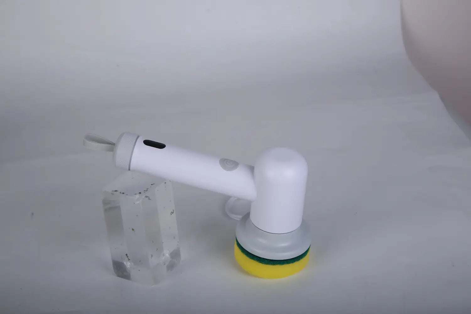 white electric spin scrubber cordless cleaning brush with a yellow and green scrubbing head designed for efficient surface cleaning.