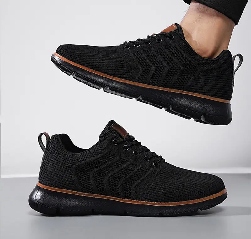 Black mesh sneakers for men casual flying woven shoes shown from the back with brown accents on the sole and heel tab.