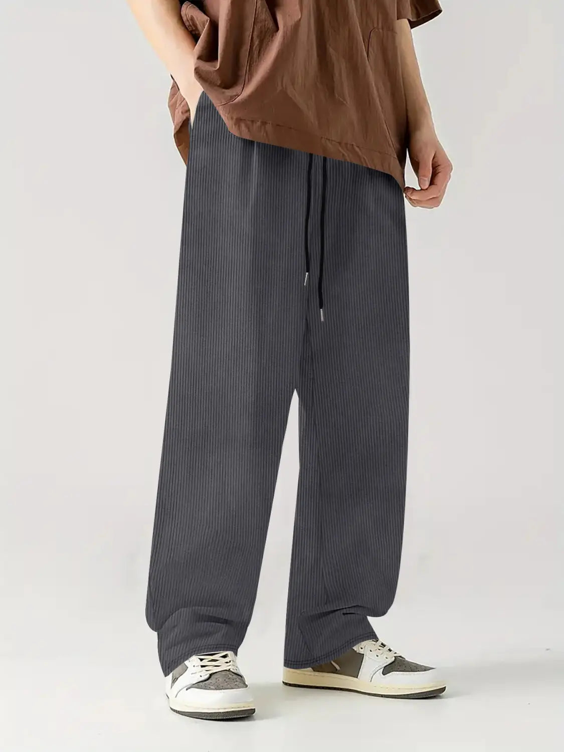 Pantalones casuales rectos de pana gris oscuro con cordón, con detalle de rayas diplomáticas y cinturilla cómoda.