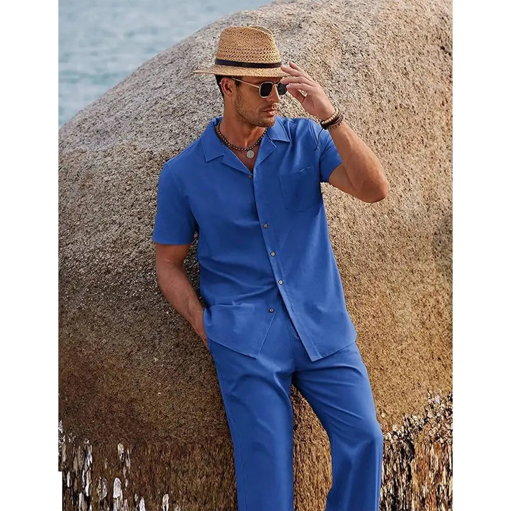 A man wearing a vibrant blue short sleeve shirt and trousers set paired with a straw hat.