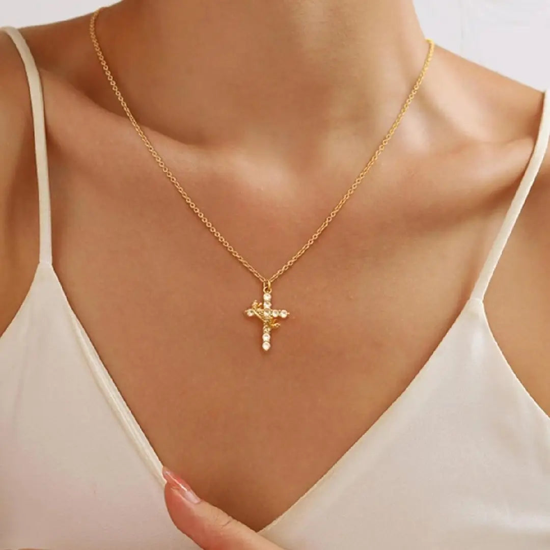 Gold-toned cross necklace with delicate chain and sparkling crystal embellishments from the sparkling layered crown and cross pendant necklace collection.