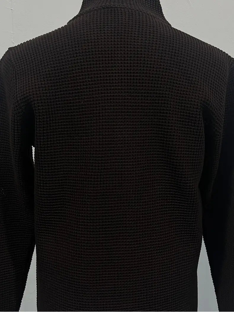 Pull-over en cardigan tricoté pour homme à col montant, en tissu noir gaufré, avec motif de côtes texturées et design de col roulé.