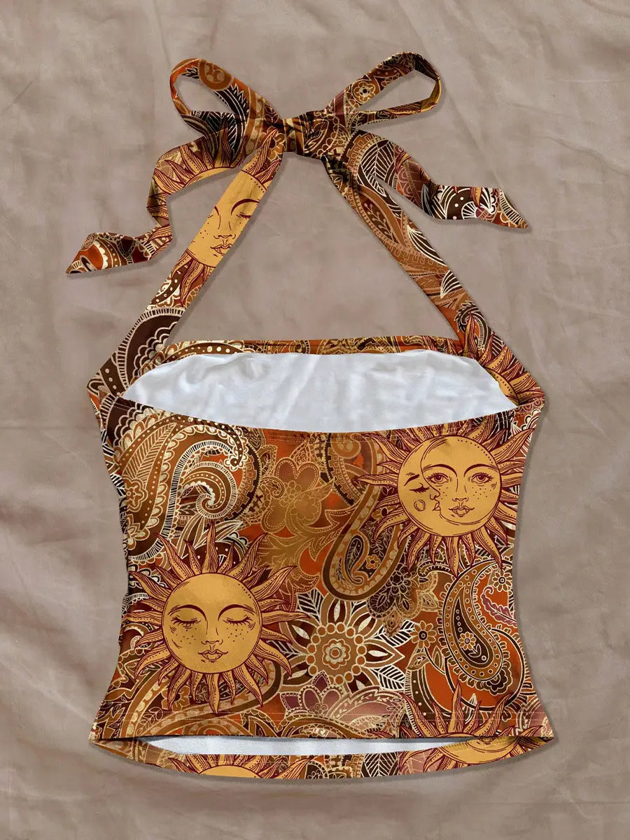 Ein eng anliegendes Paisley-Haltertop in leuchtendem Orange und Braun mit Sonnen-Gesichtern mit geschlossenen Augen aus weichem, bedrucktem Stoff.