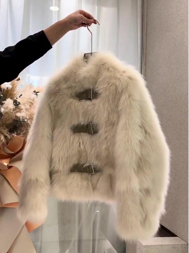 Cream-colored faux fur coat featuring three horizontal metal buckle closures for a stylish outerwear option.
