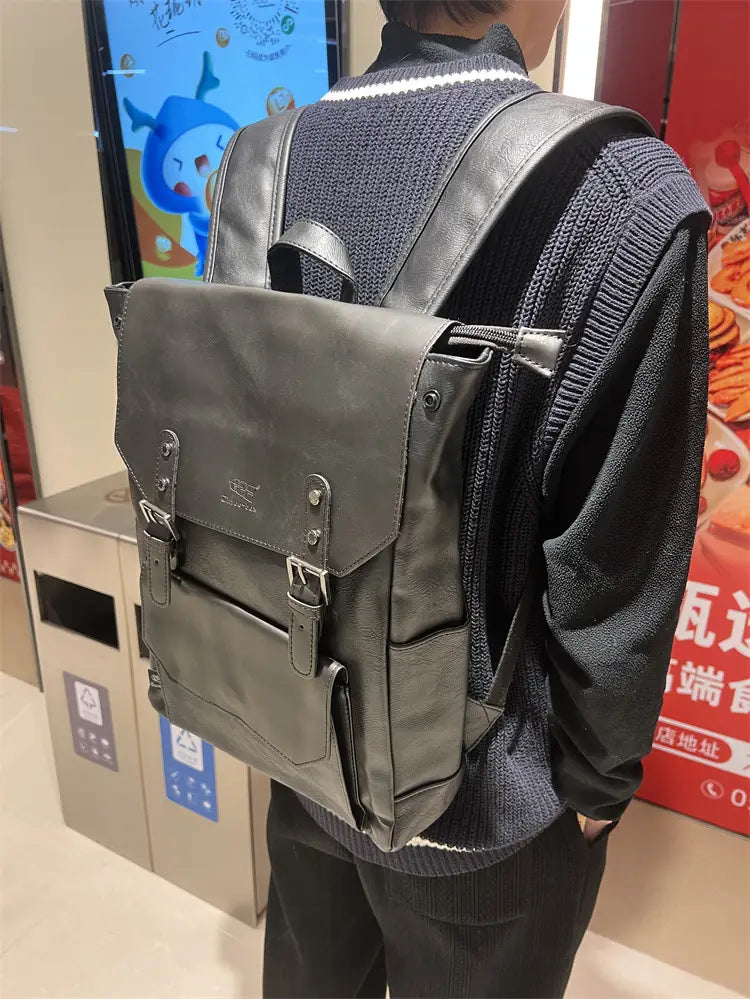Dark gray leather vintage college backpack with large capacity silver-toned metal buckles and front flap closure for travel use.