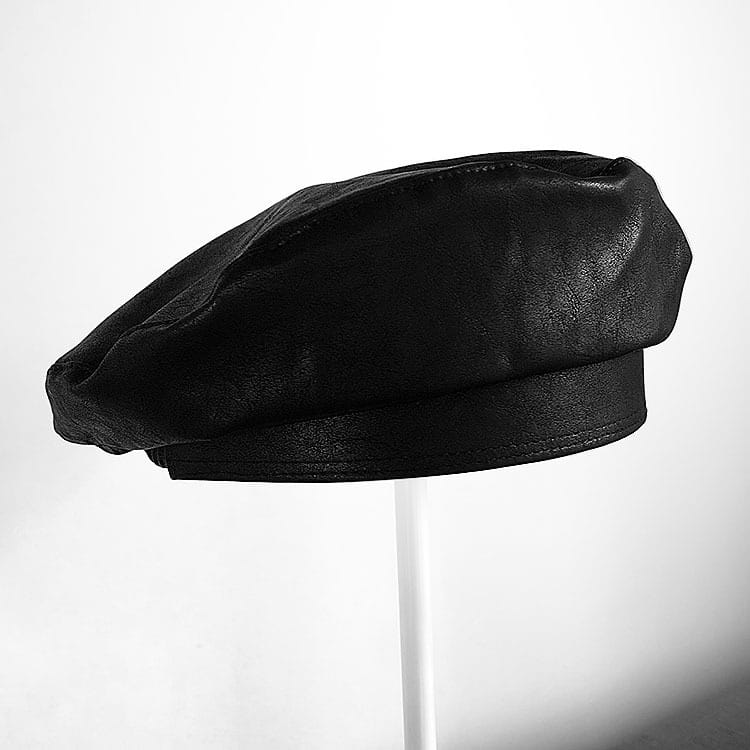 Béret en laine béret noir pour peintre pour femmes, présentant un matériau en cuir noir, avec une texture souple légèrement froissée et une couture soignée le long de la bordure.