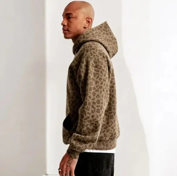 Un hoodie oversize à imprimé léopard beige, à la coupe ample, avec des poignets côtelés, conçu pour l’habillement d’hiver vintage pour hommes.