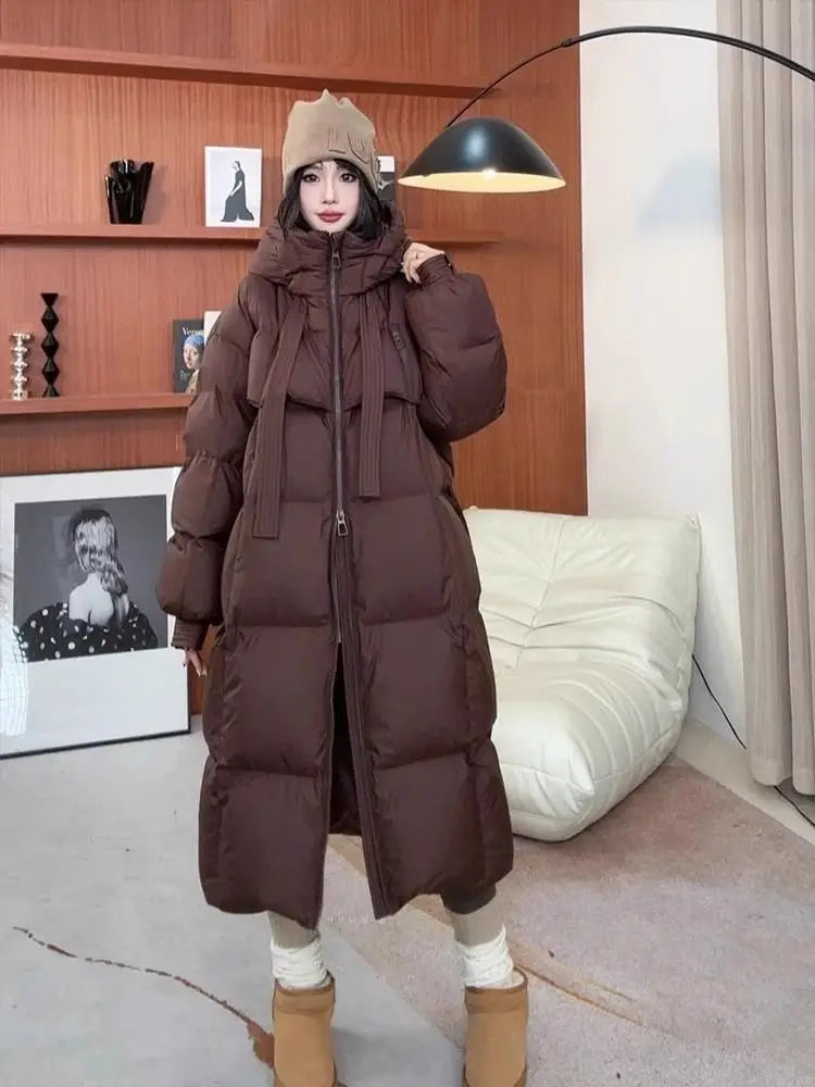 A long chocolate brown padded down jacket quilted coat with a hood and front zipper for women.